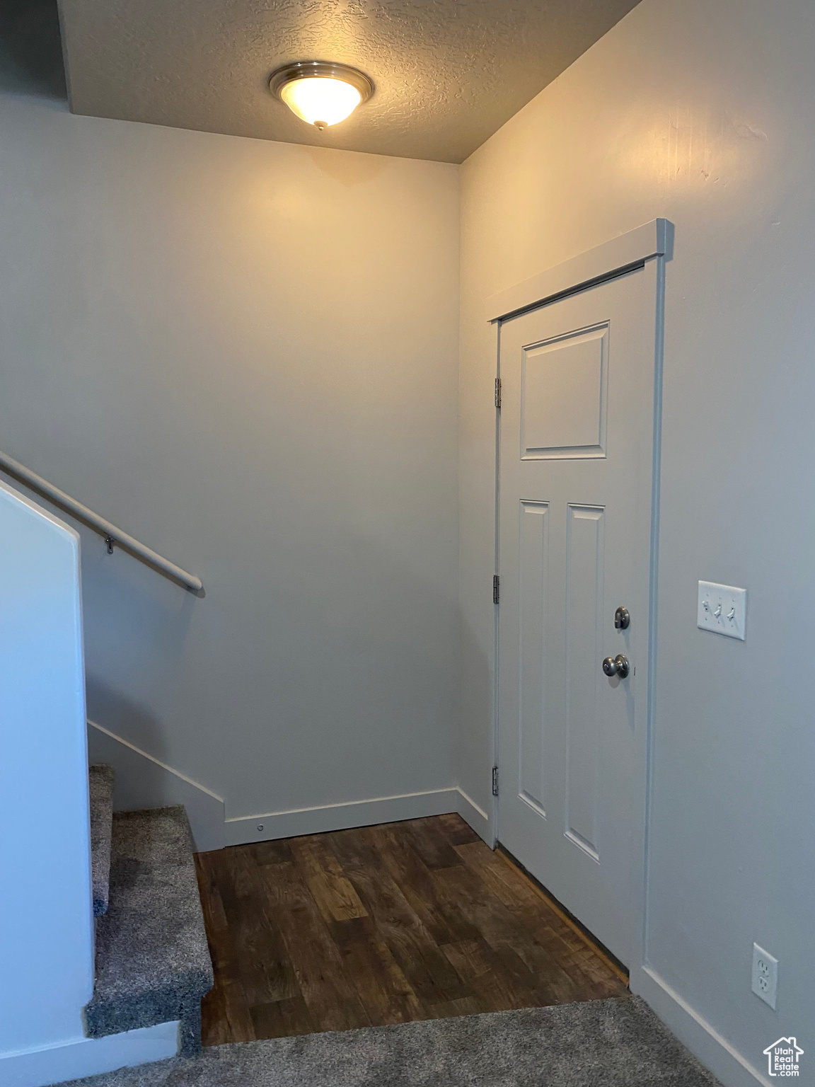 Foyer entrance featuring a textured ceiling and dark wood-type flooring