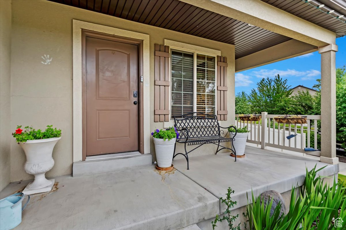 View of exterior entry featuring covered porch