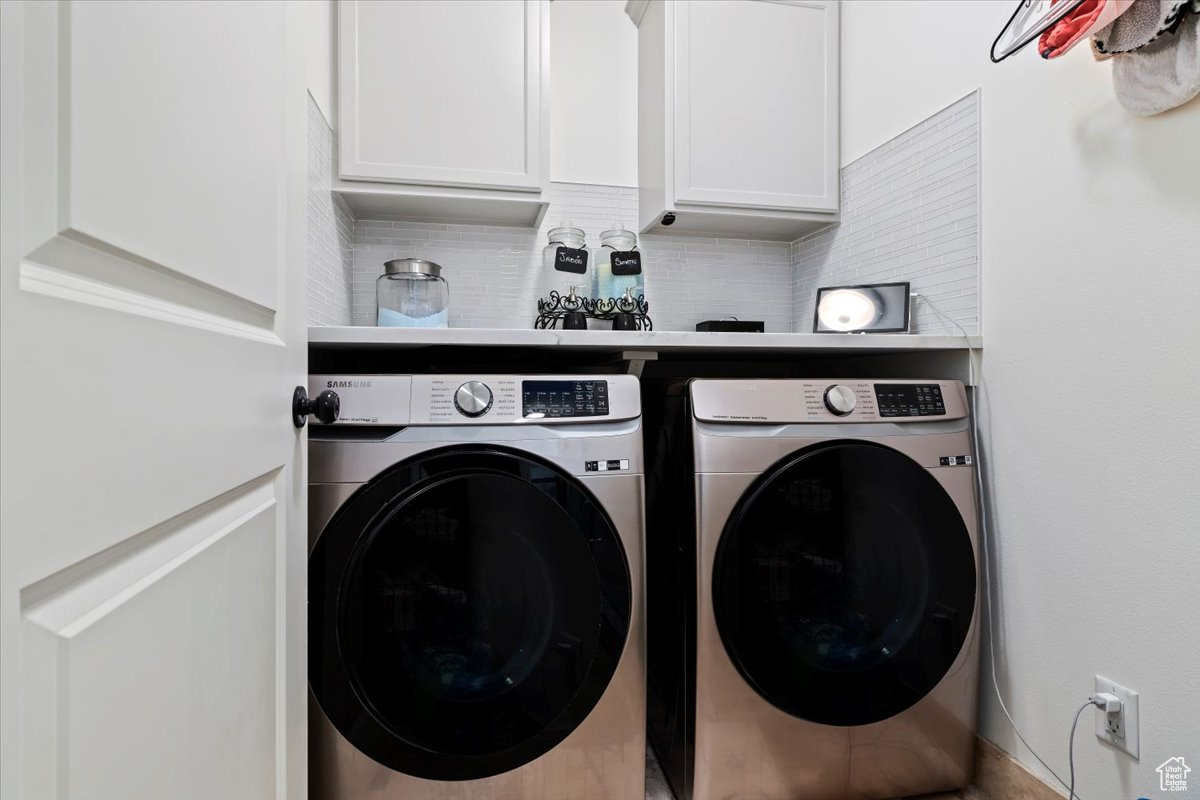 Laundry room with cabinets and washing machine and clothes dryer