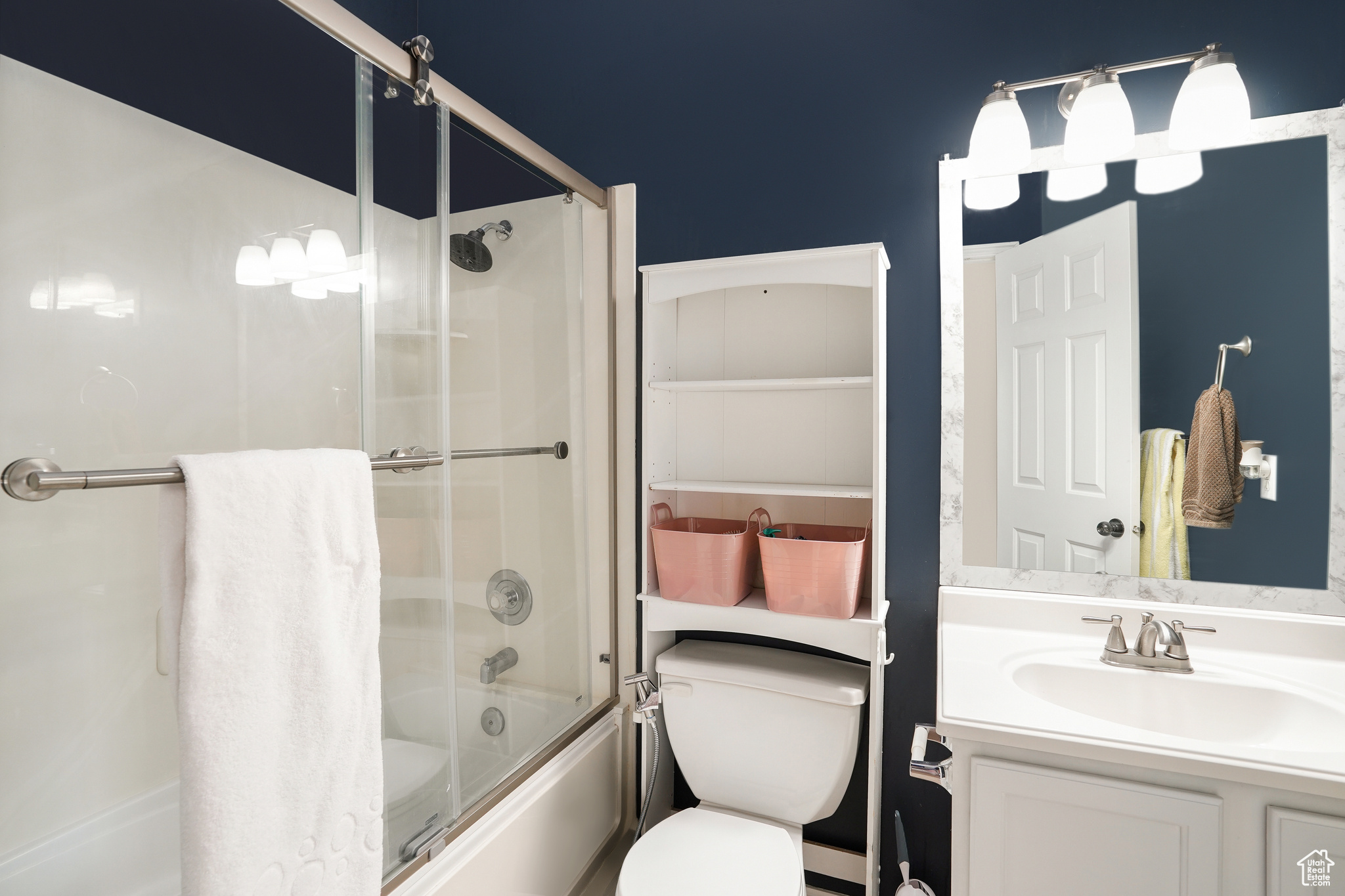 Full bathroom with shower / bath combination with glass door, oversized vanity, and toilet