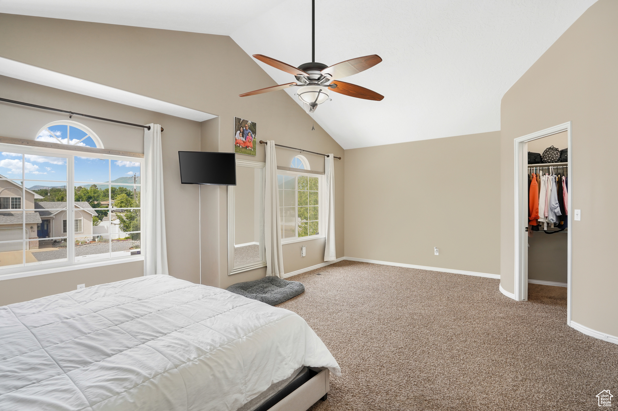 Carpeted bedroom featuring ceiling fan, a closet, lofted ceiling, and a spacious closet