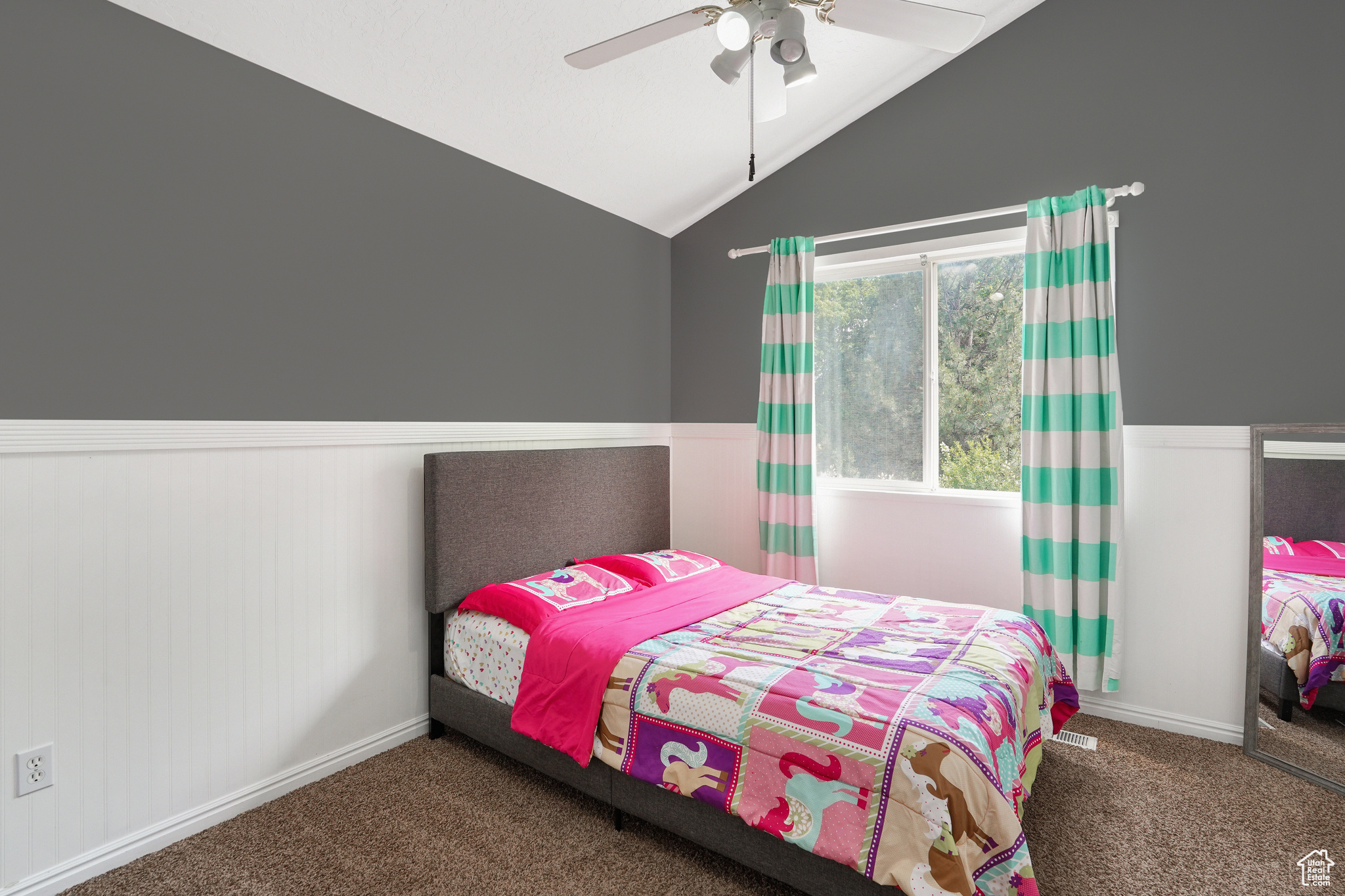 Bedroom with lofted ceiling, dark colored carpet, and ceiling fan