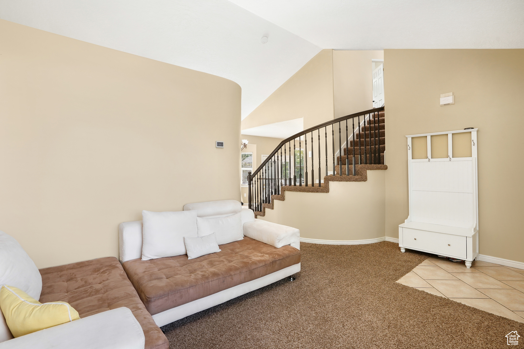 Carpeted living room featuring high vaulted ceiling