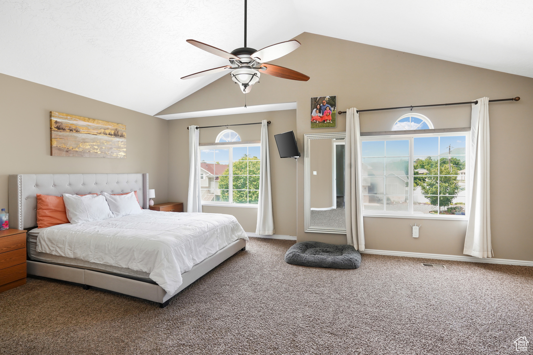 Carpeted bedroom with high vaulted ceiling and ceiling fan