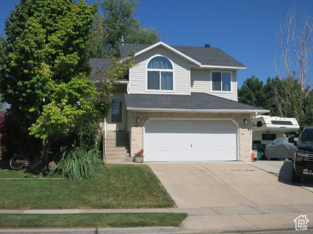View of front of home featuring a front yard and a garage
