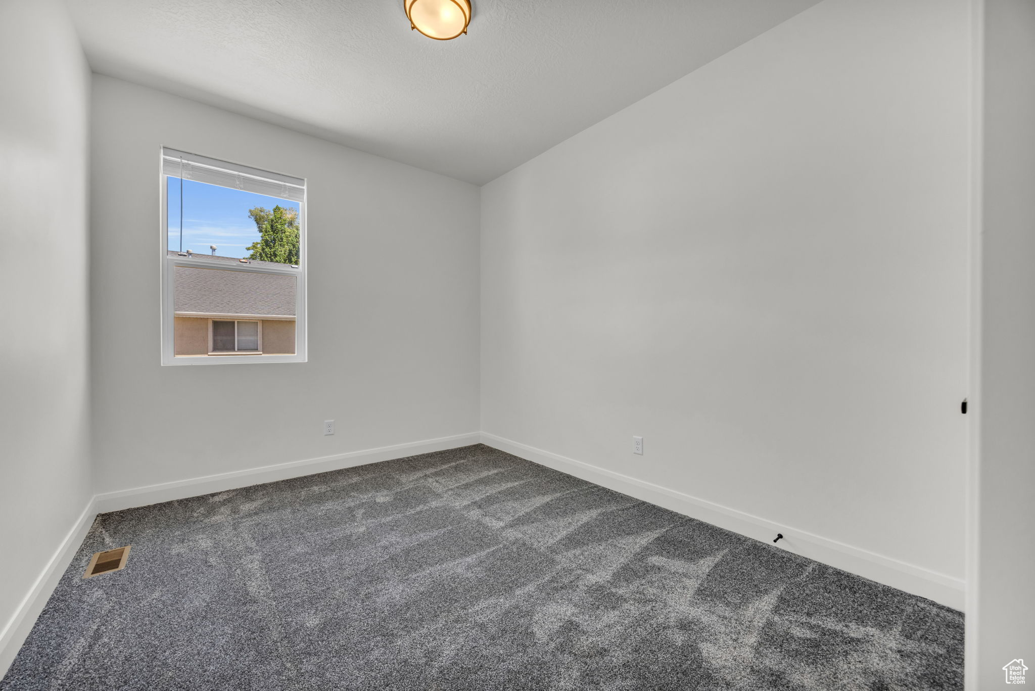 Unfurnished room featuring dark colored carpet