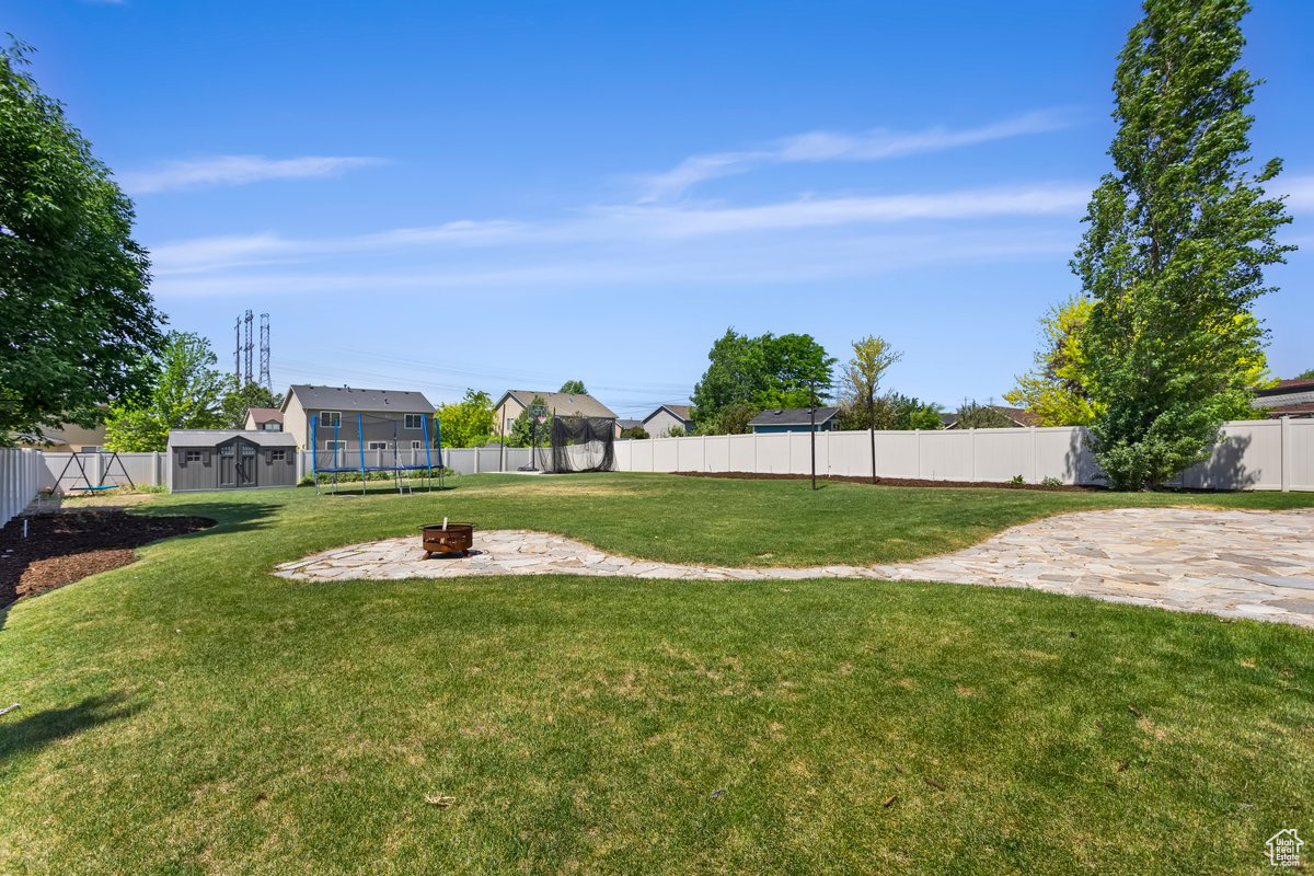 View of yard with an outdoor fire pit and a patio