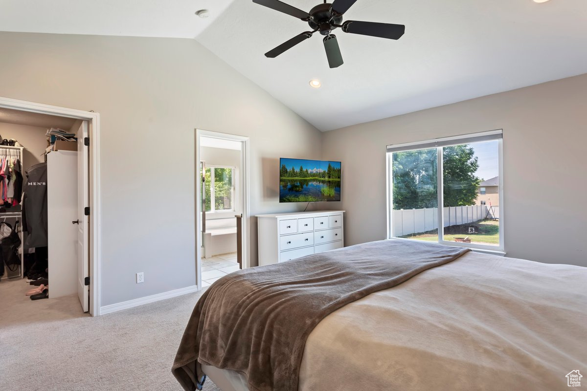 Bedroom featuring vaulted ceiling, a closet, ceiling fan, connected bathroom, and a spacious closet