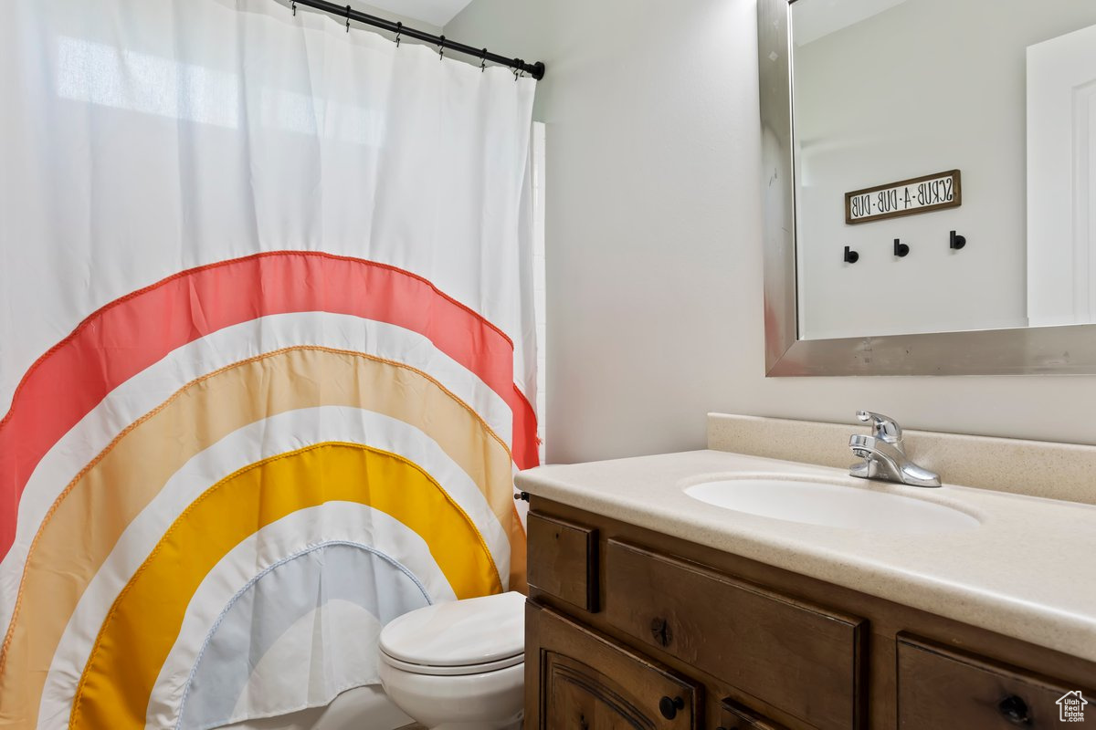 Bathroom with toilet and vanity with extensive cabinet space