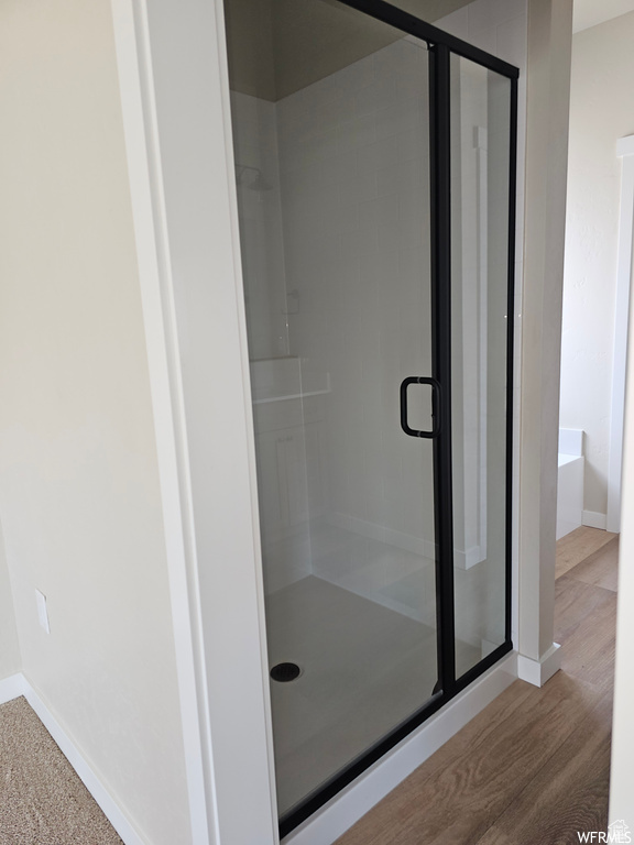 Bathroom with separate shower and tub and hardwood / wood-style floors