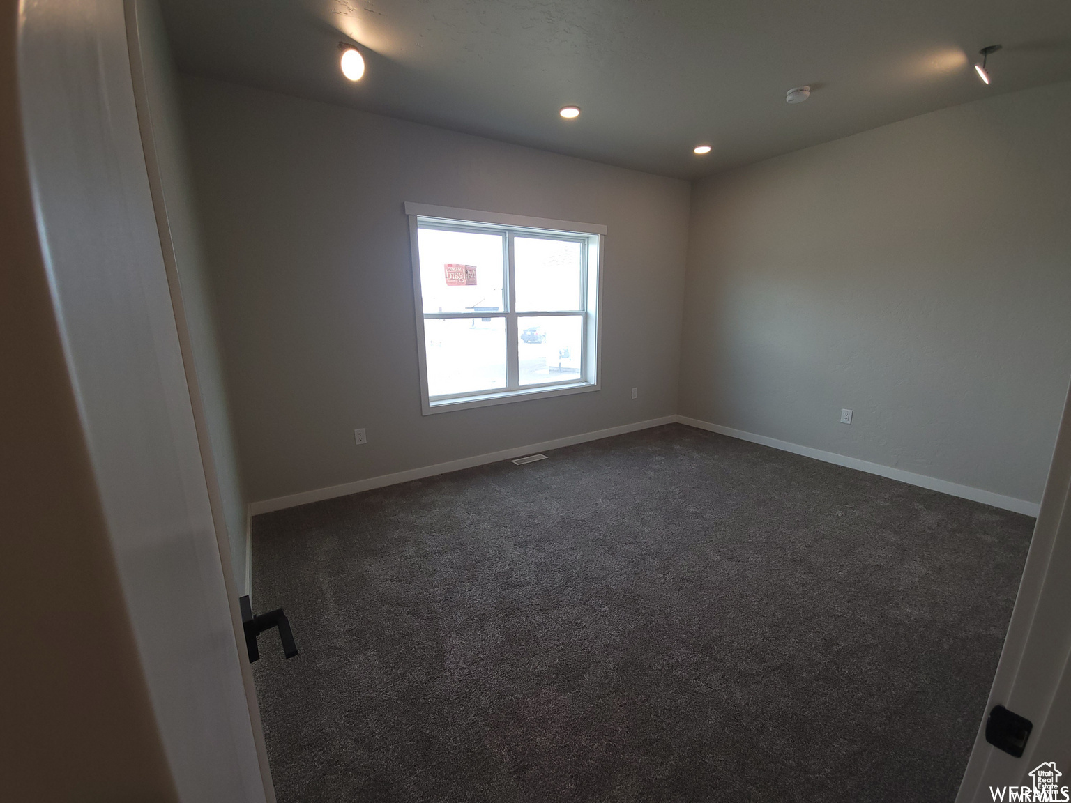 Unfurnished room with dark carpet