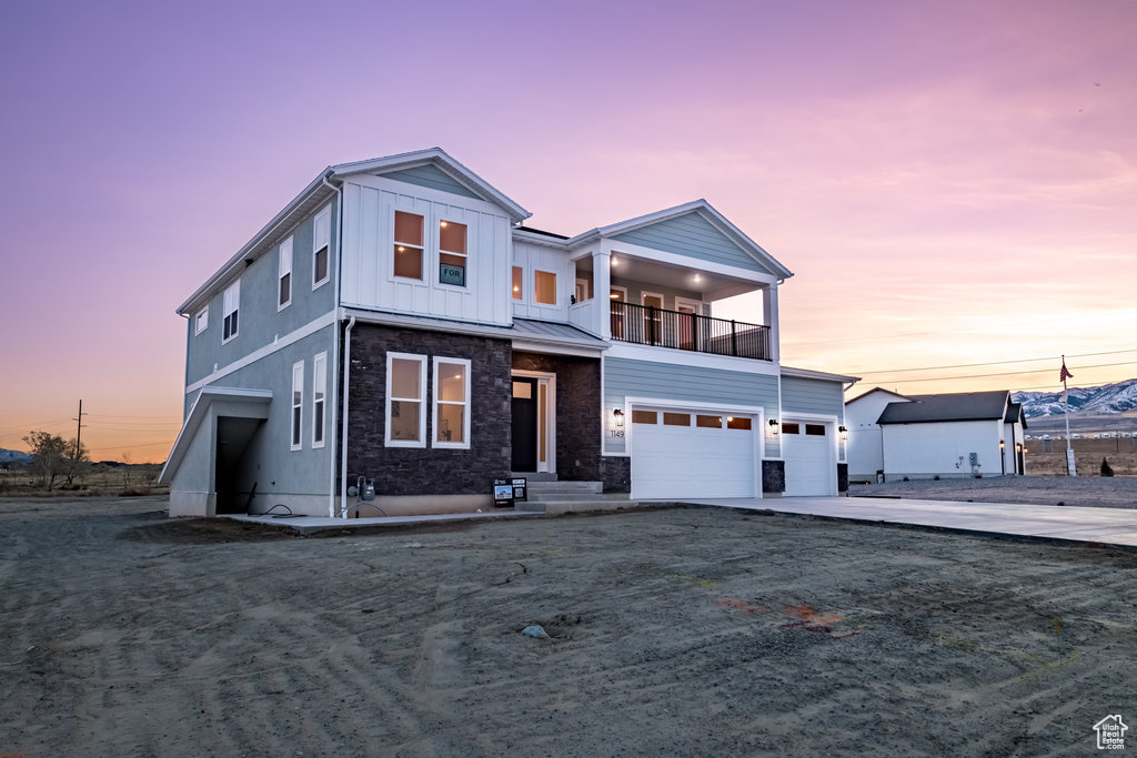 View of front of home featuring a balcony and a garage