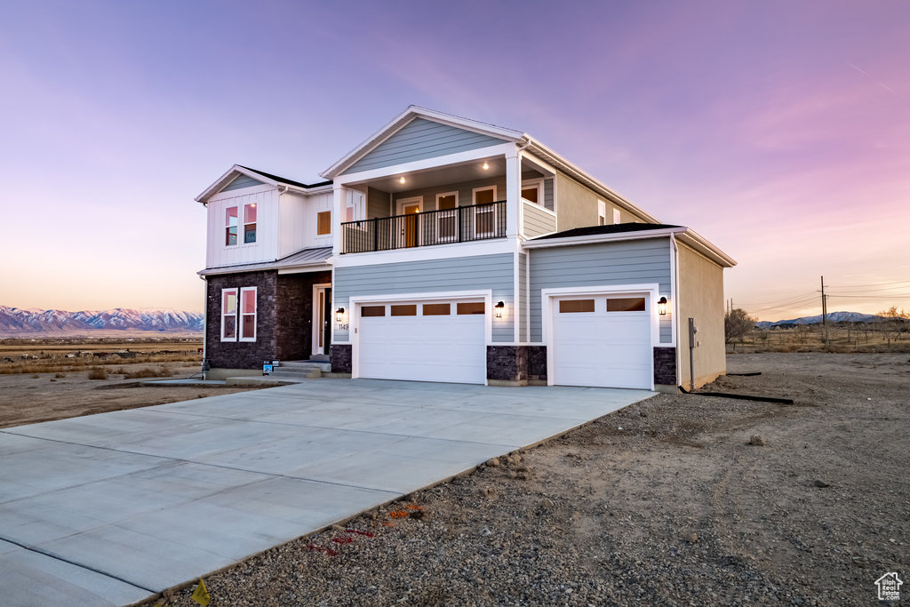 View of front facade featuring a balcony and a garage