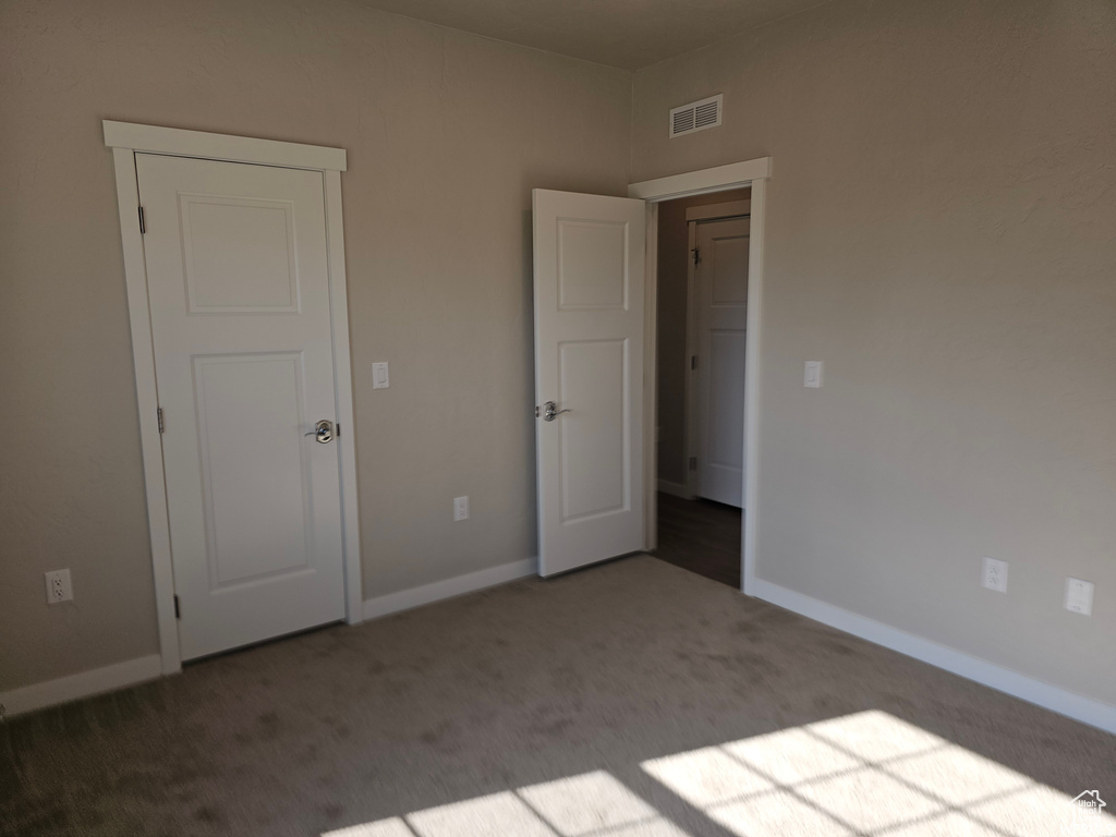 Unfurnished bedroom with carpet flooring