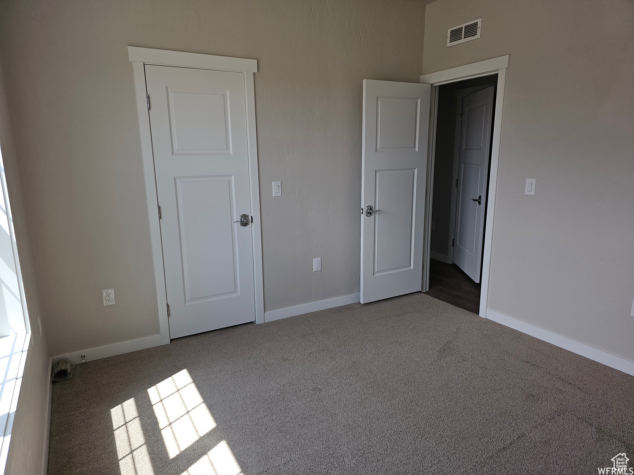 Unfurnished bedroom featuring dark carpet