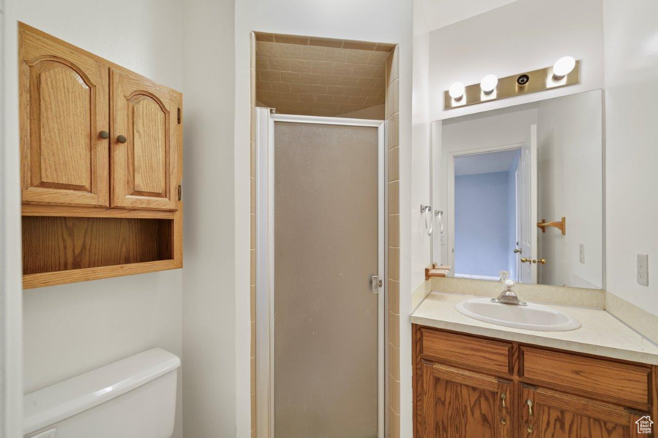 Bathroom with walk in shower, toilet, and large vanity