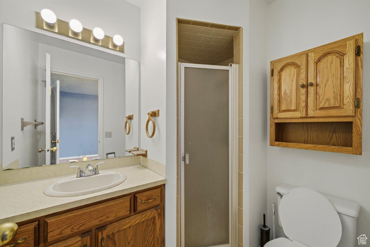 Bathroom featuring walk in shower, toilet, and vanity