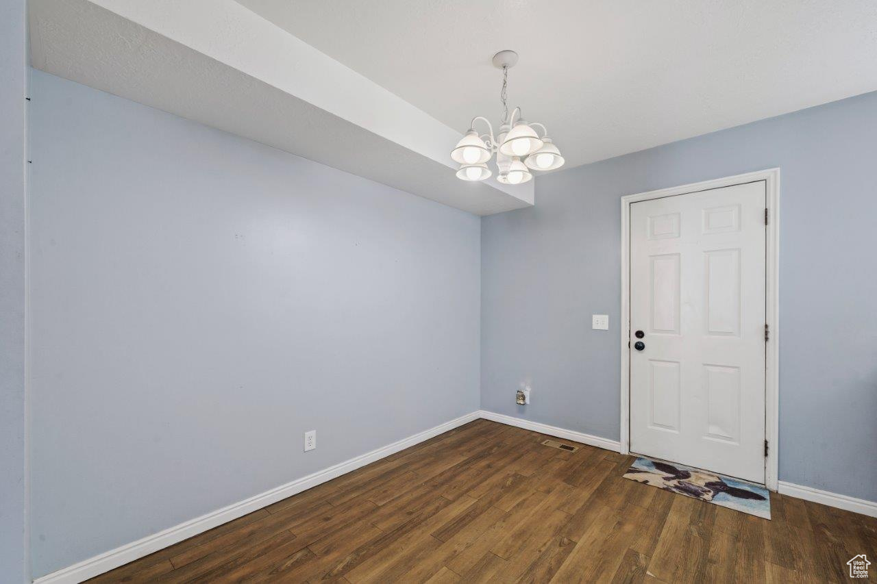 Bedoom featuring wood-type flooring and an inviting chandelier