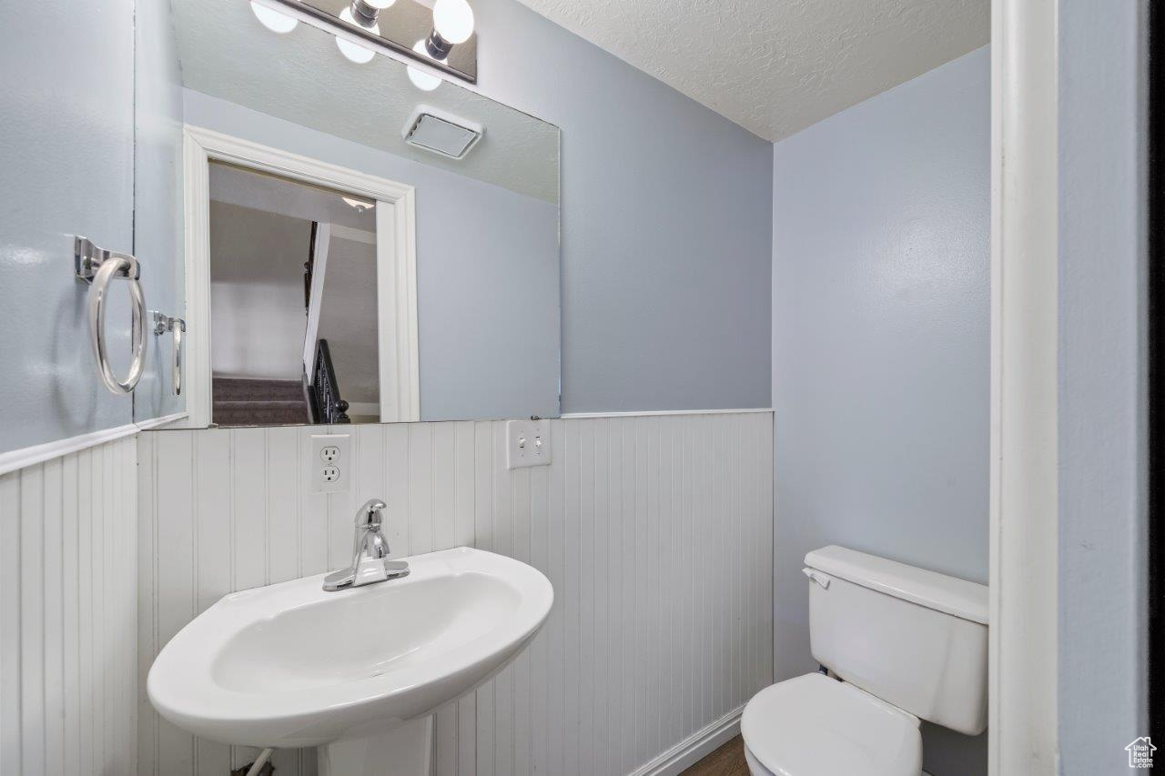 Bathroom with sink, toilet, and a textured ceiling