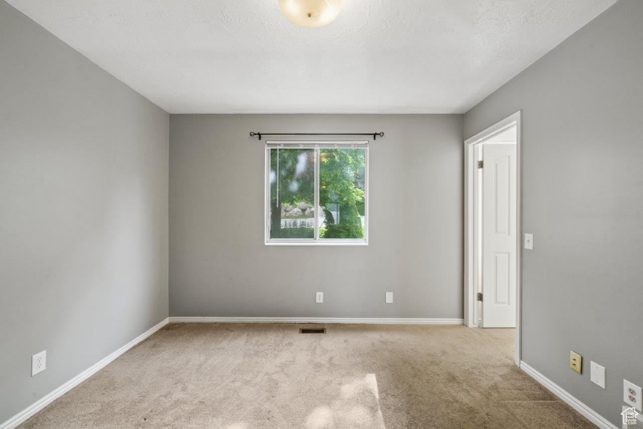 Spare room featuring a textured ceiling and light colored carpet