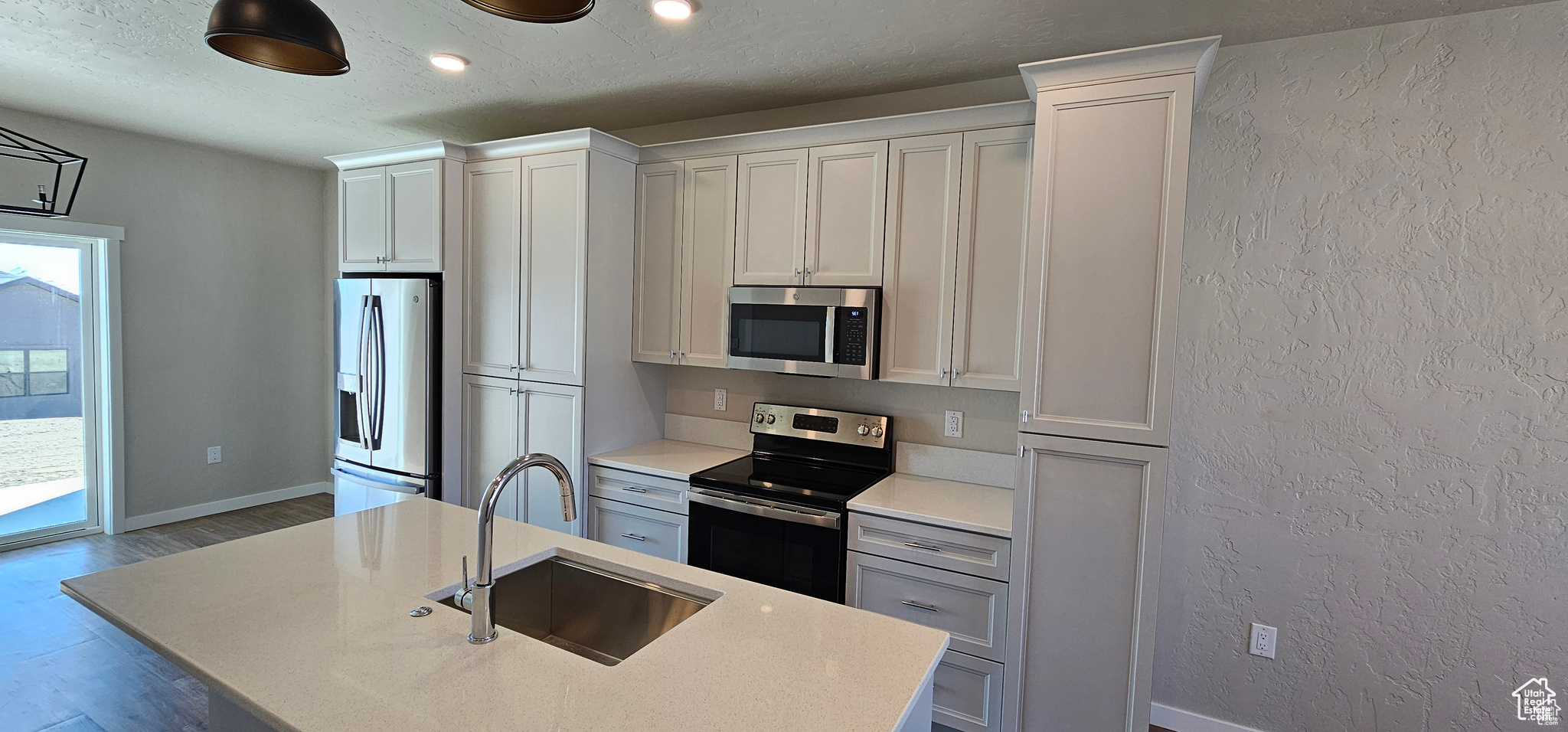 Kitchen featuring sink, a center island with sink, and appliances with stainless steel finishes