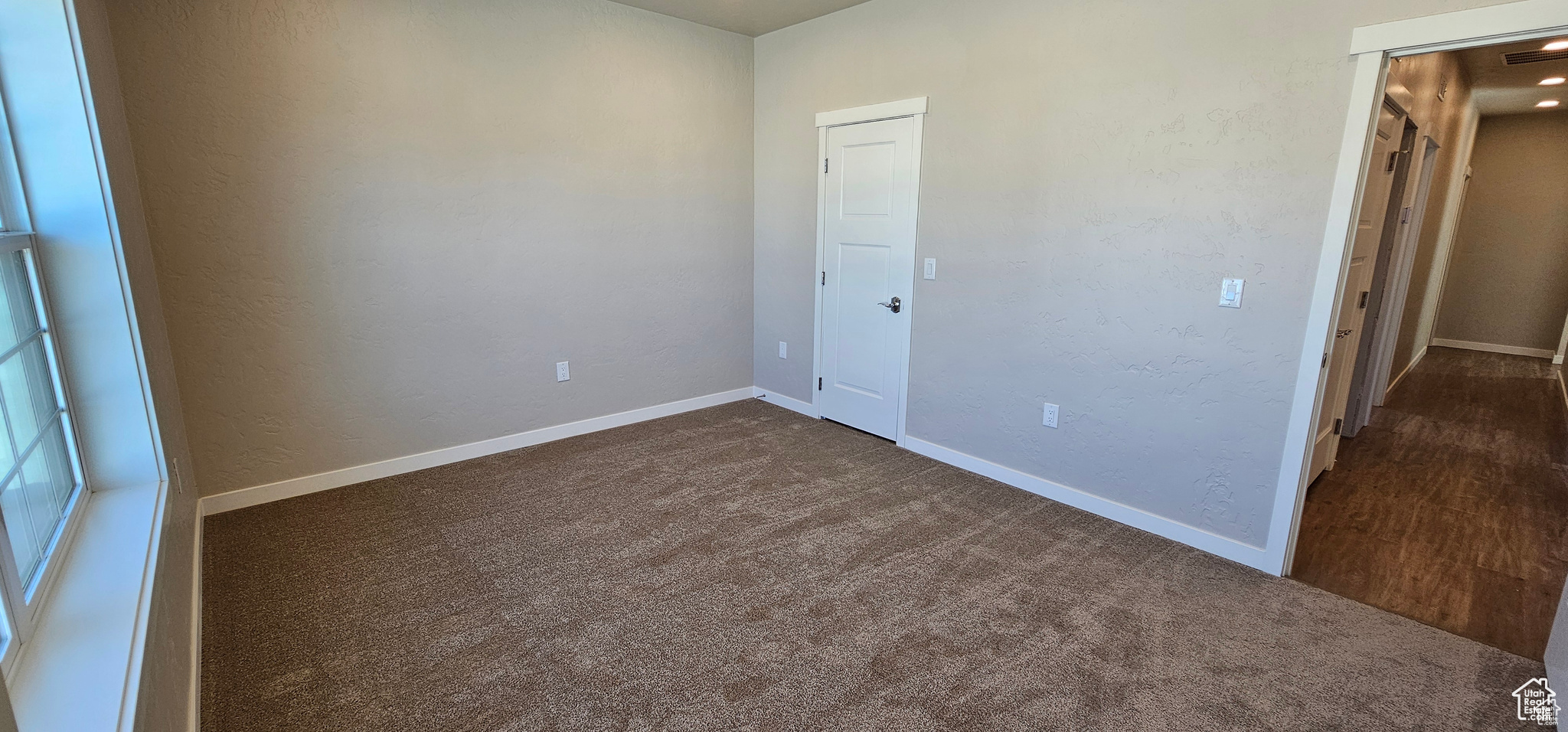 Unfurnished bedroom with dark colored carpet