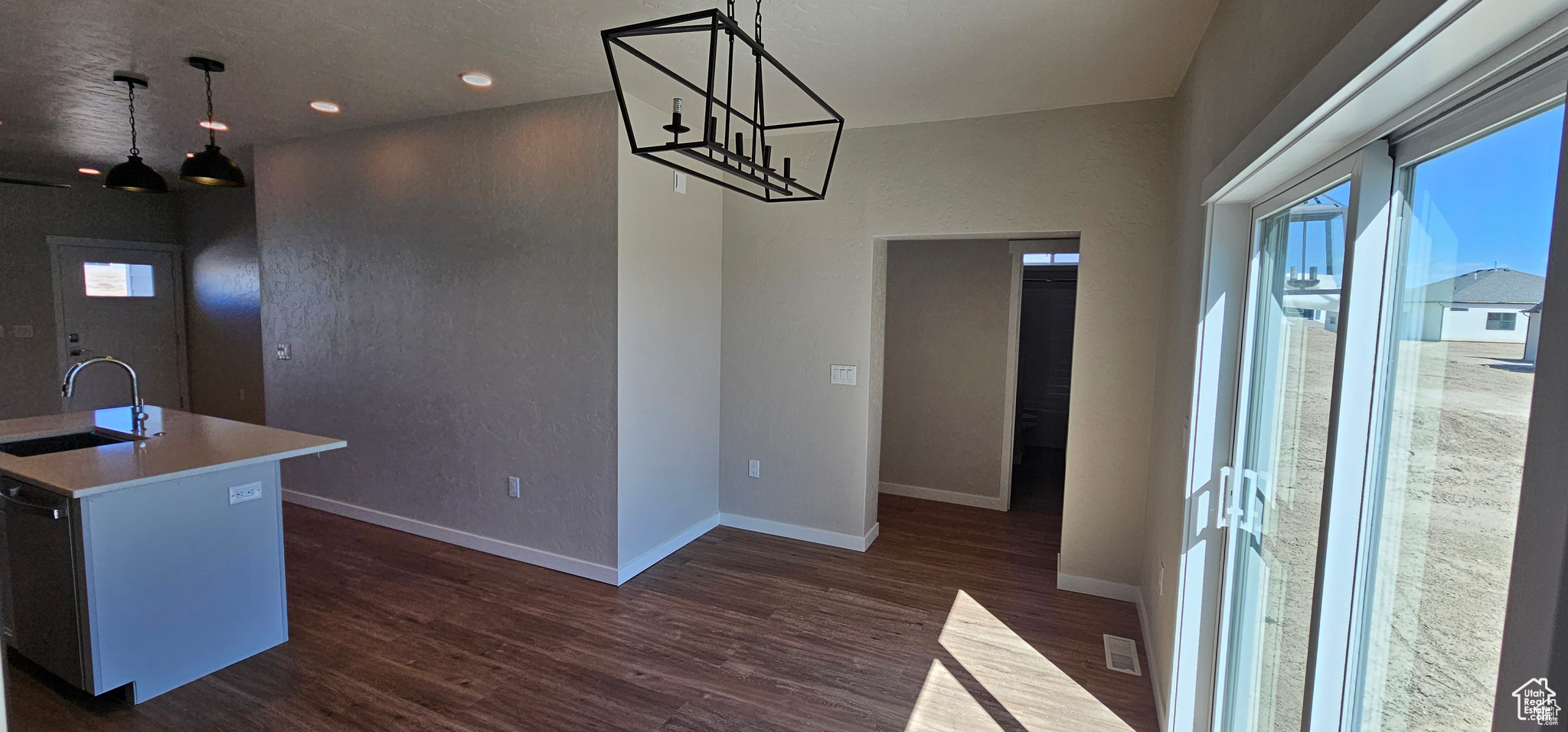 Dining room with a chandelier, sink, and dark wood-type flooring