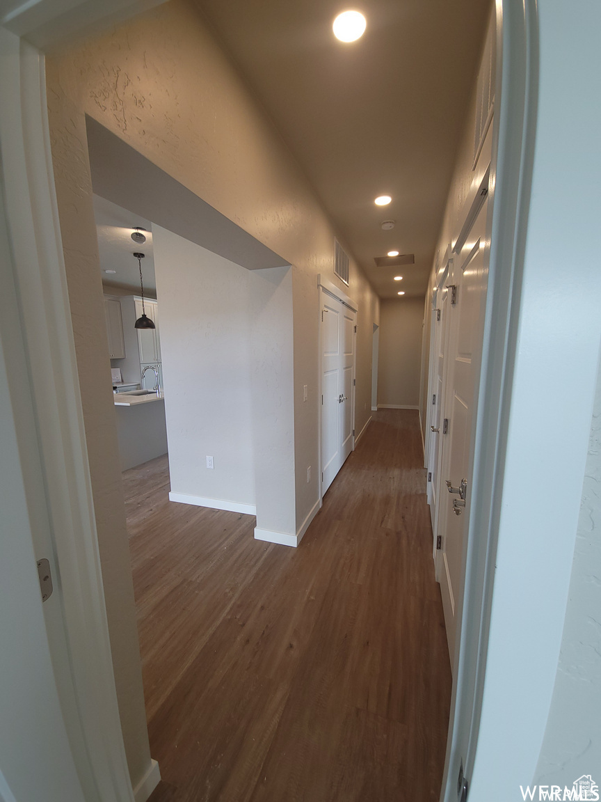 Corridor with dark hardwood / wood-style flooring