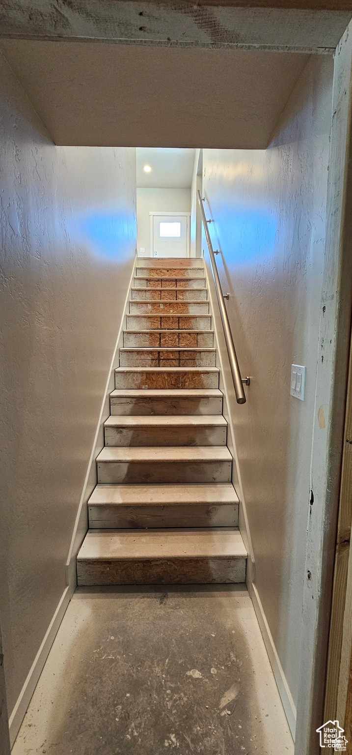 Stairway featuring concrete floors