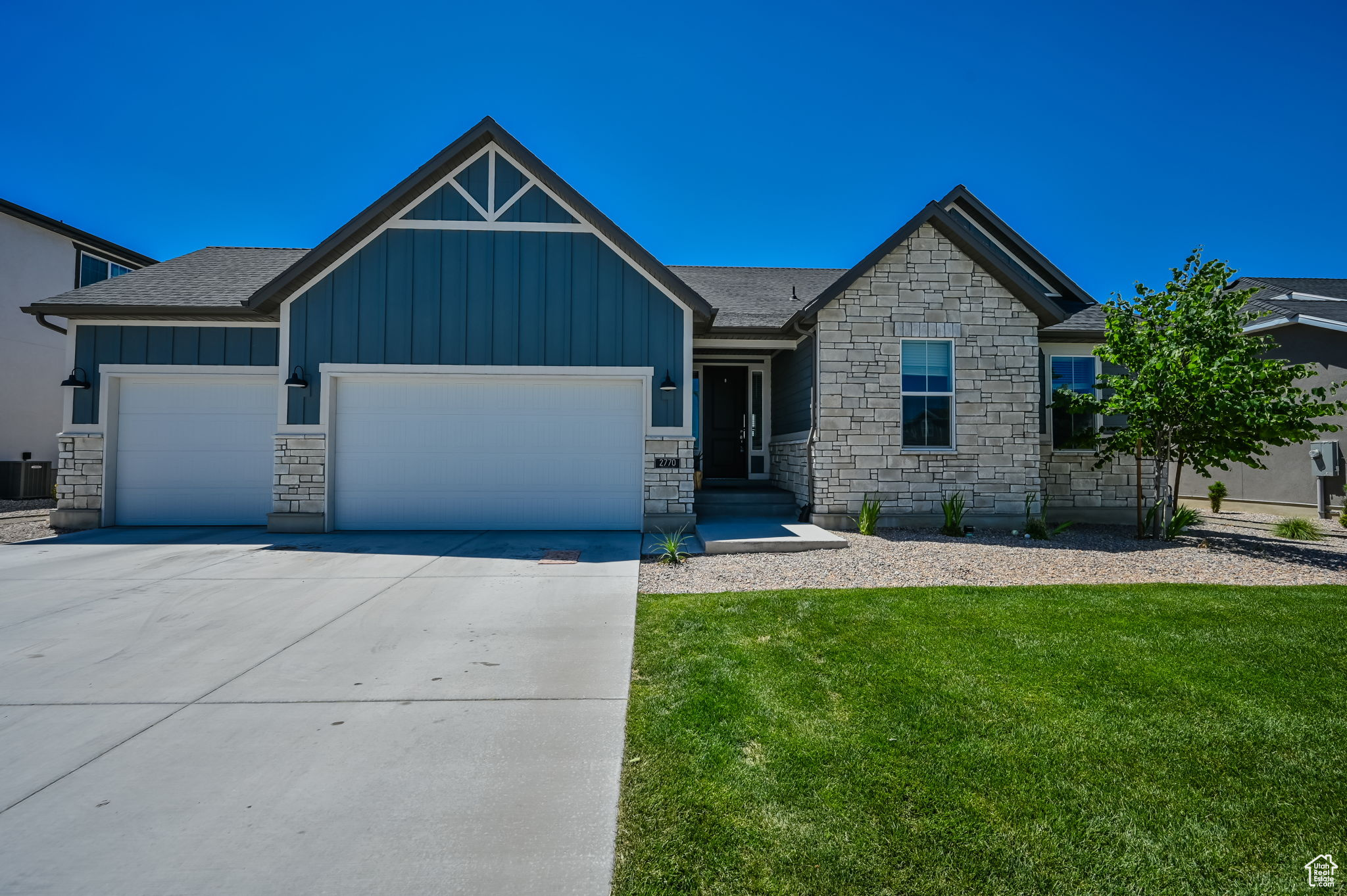 Craftsman house featuring a garage and a front lawn