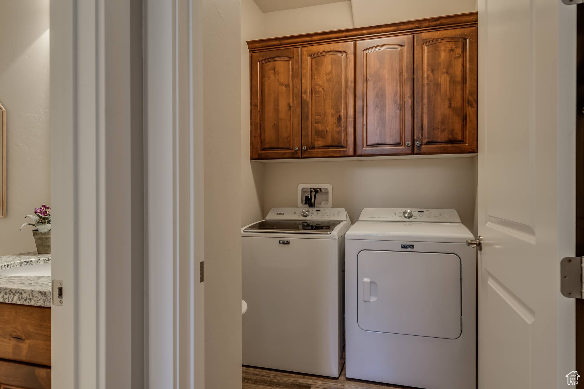 Laundry room featuring cabinets, hardwood / wood-style flooring, hookup for a washing machine, and washing machine and clothes dryer