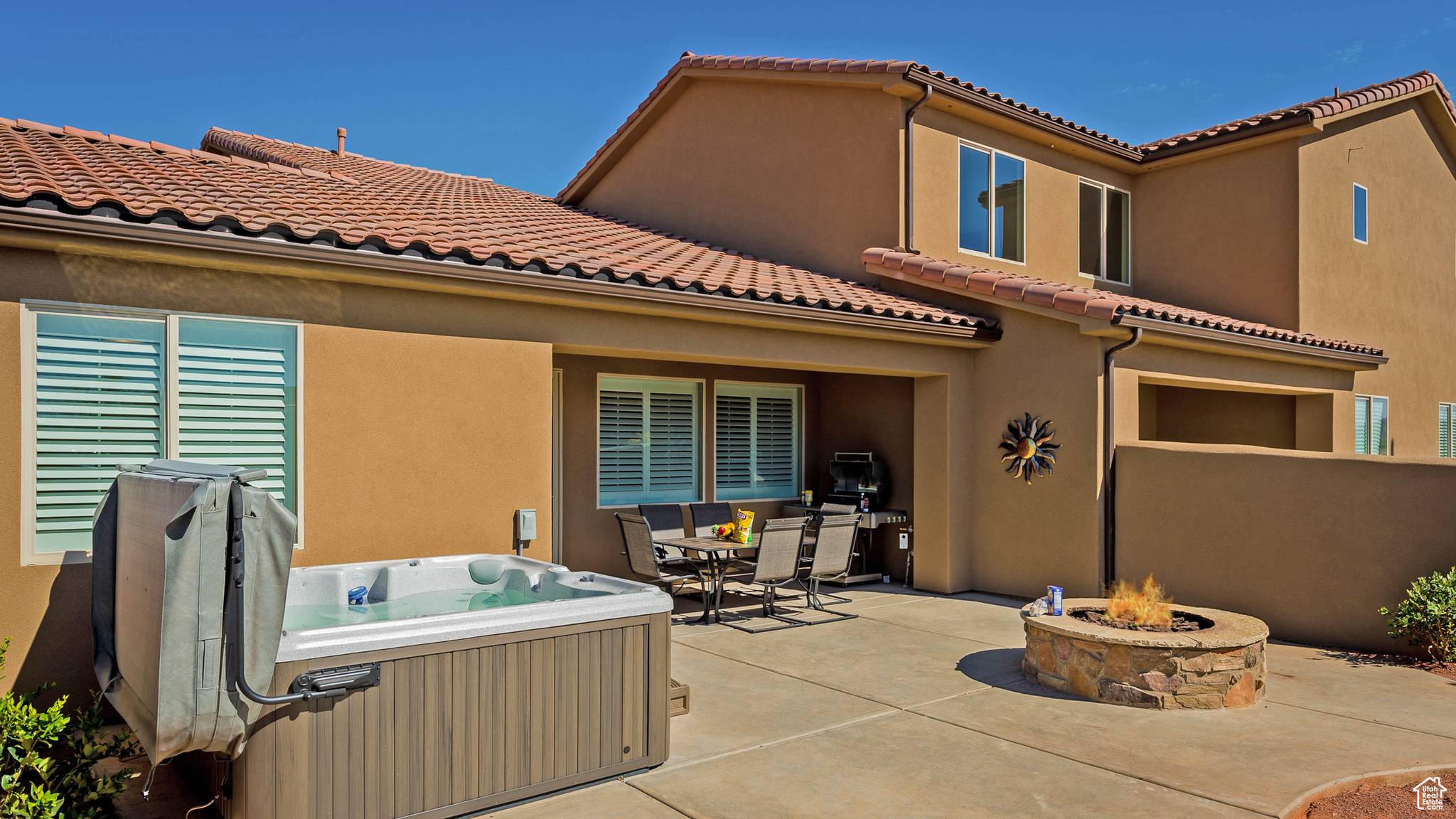 View of terrace featuring a hot tub and a fire pit