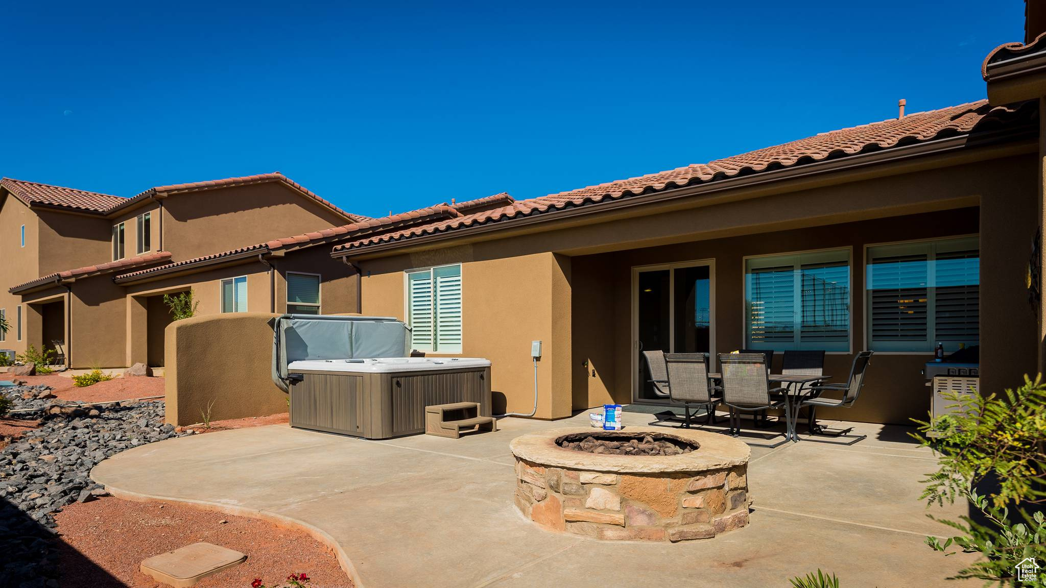 View of terrace featuring an outdoor fire pit and a hot tub