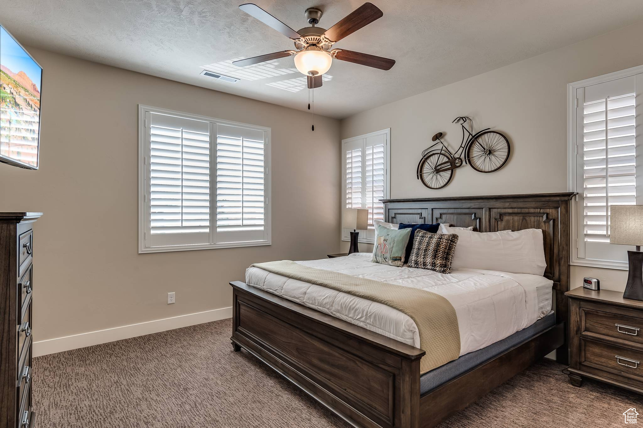 Master bedroom with multiple windows and ceiling fan