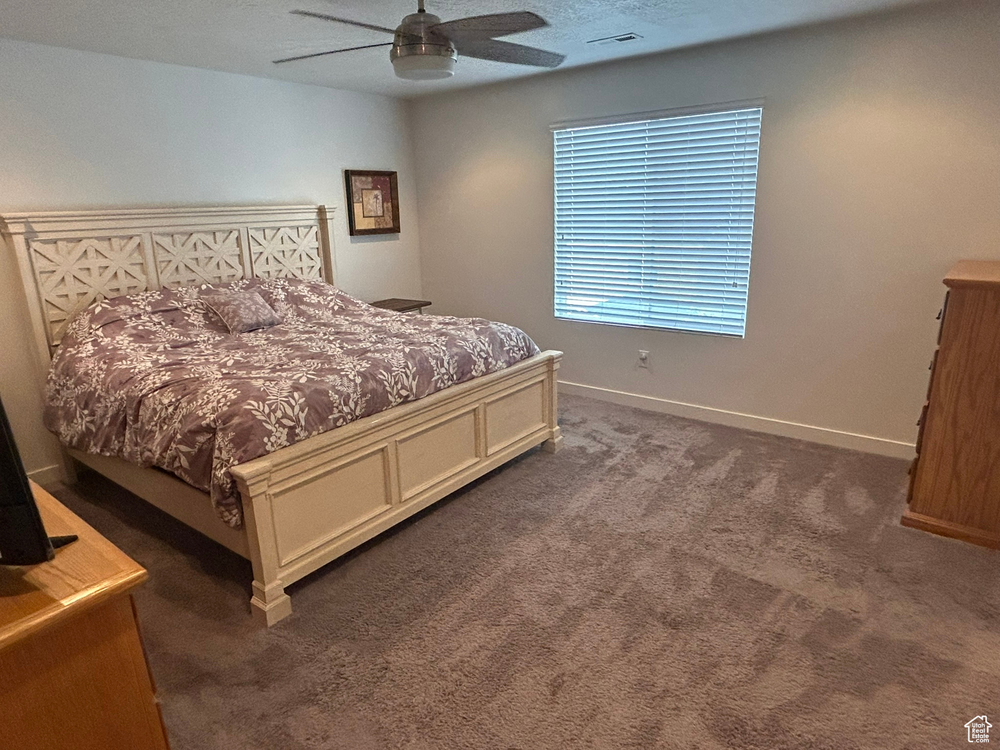 Bedroom featuring ceiling fan and dark carpet