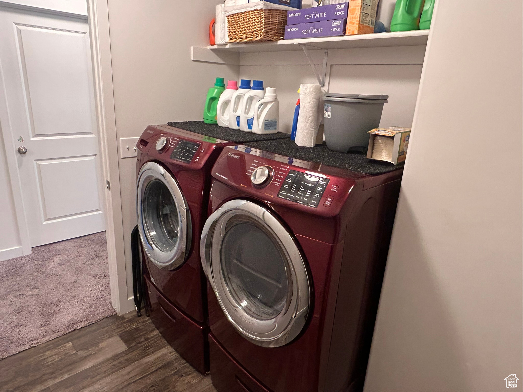 Clothes washing area featuring dark wood-type flooring and washing machine and clothes dryer