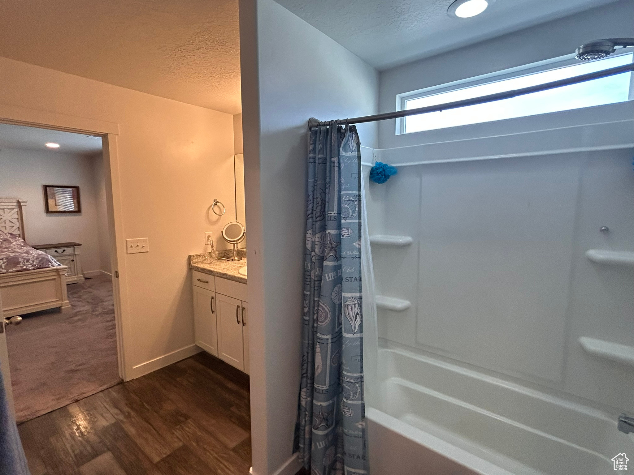 Bathroom featuring shower / bath combination with curtain, a textured ceiling, vanity, and wood-type flooring