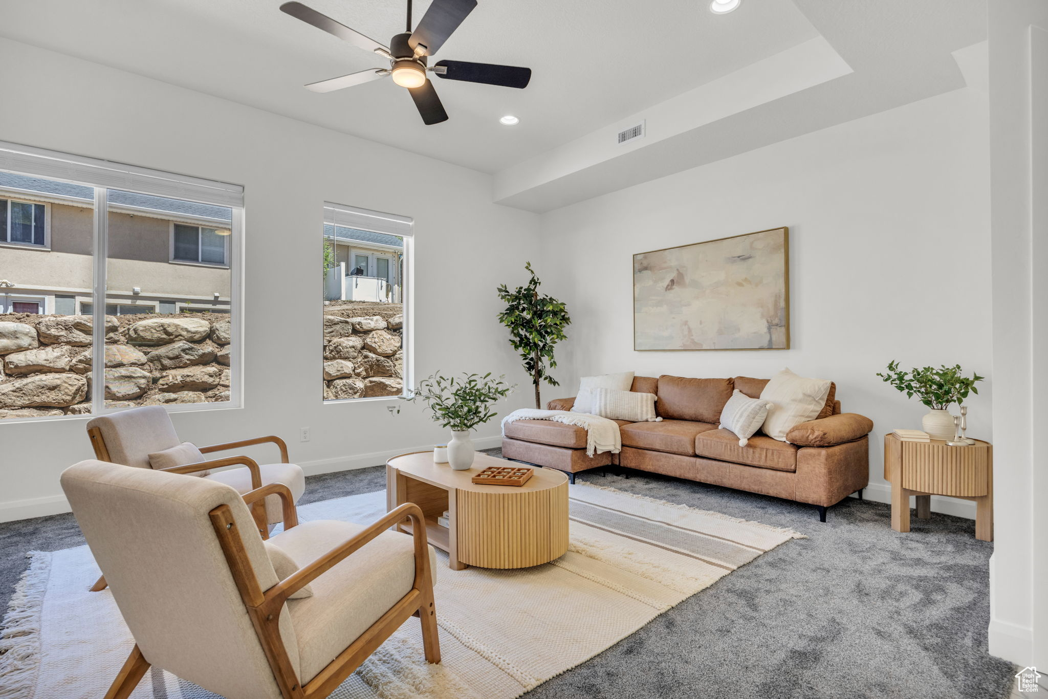 Carpeted living room featuring ceiling fan