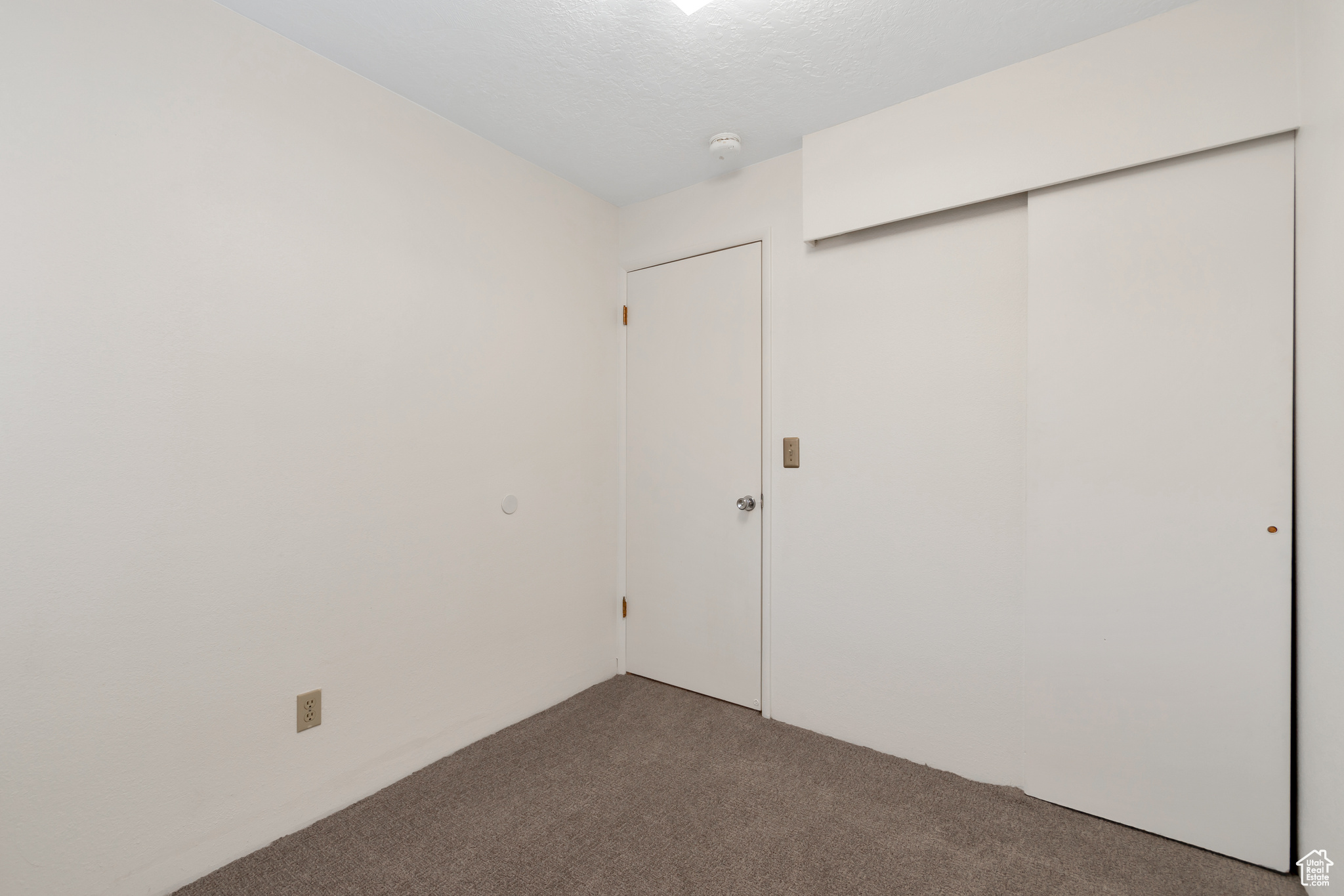 Unfurnished bedroom featuring carpet and a closet