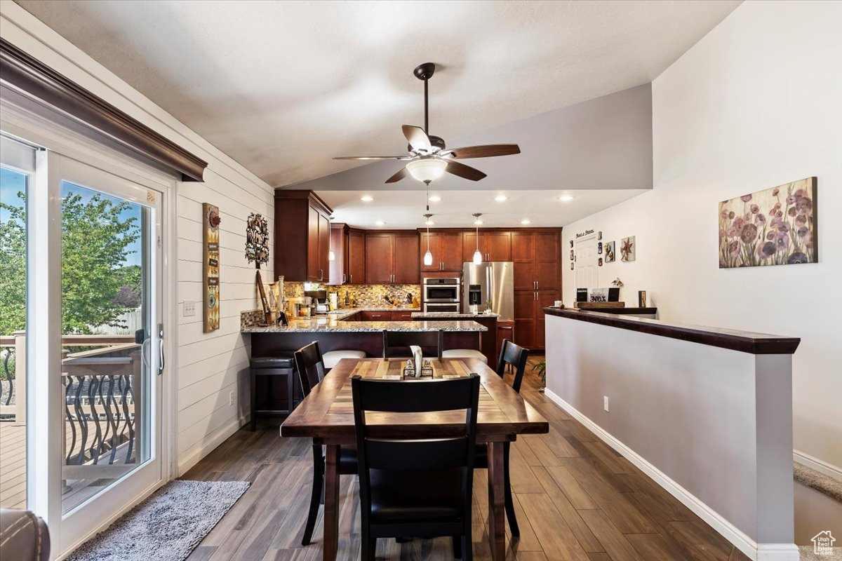 Dining area with dark hardwood / wood-style floors, ceiling fan, and lofted ceiling