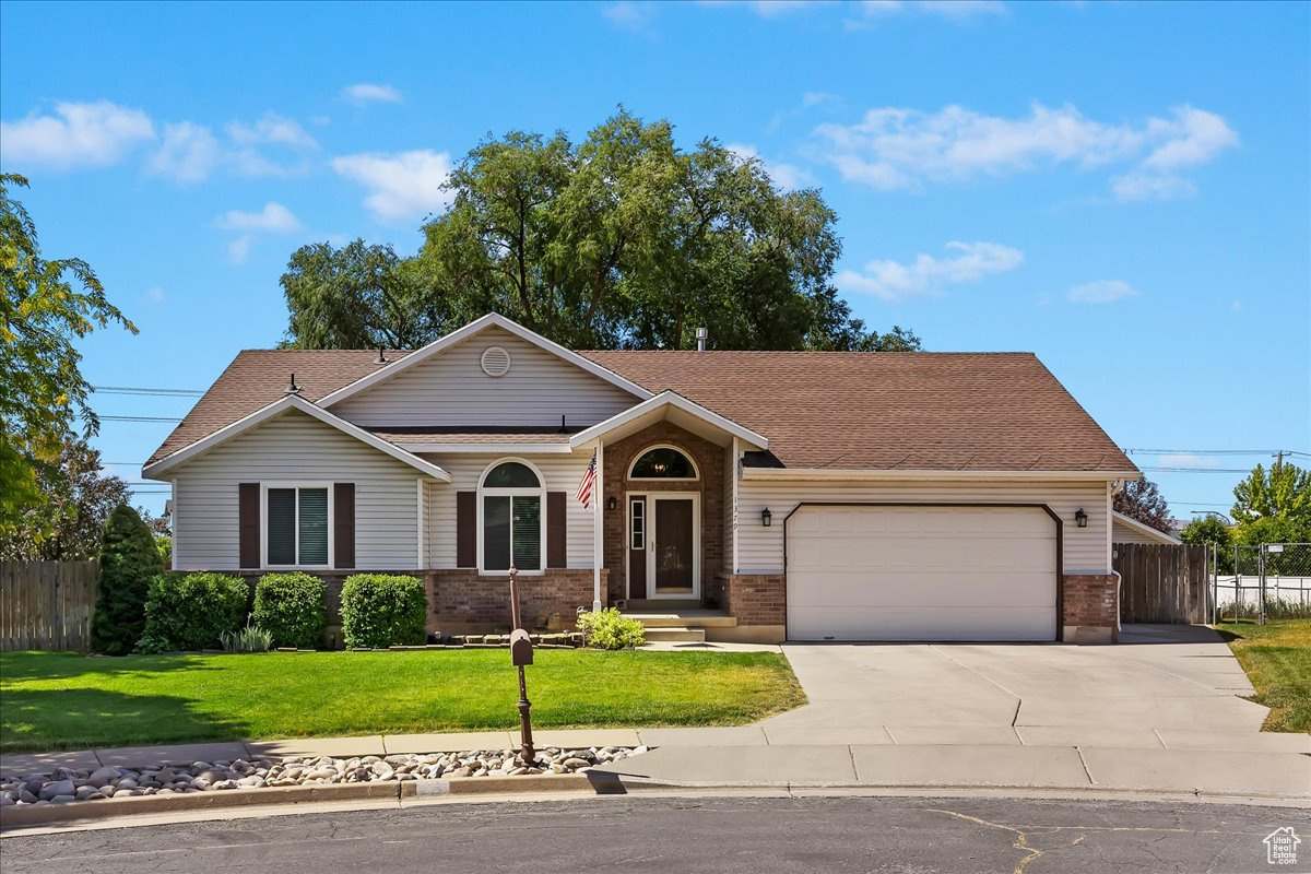 Single story home featuring a garage and a front lawn