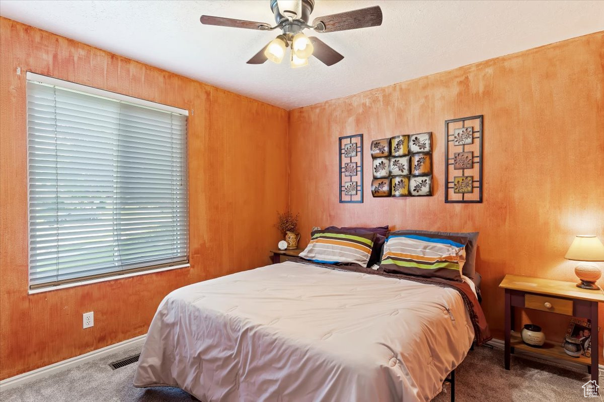 Carpeted bedroom with ceiling fan