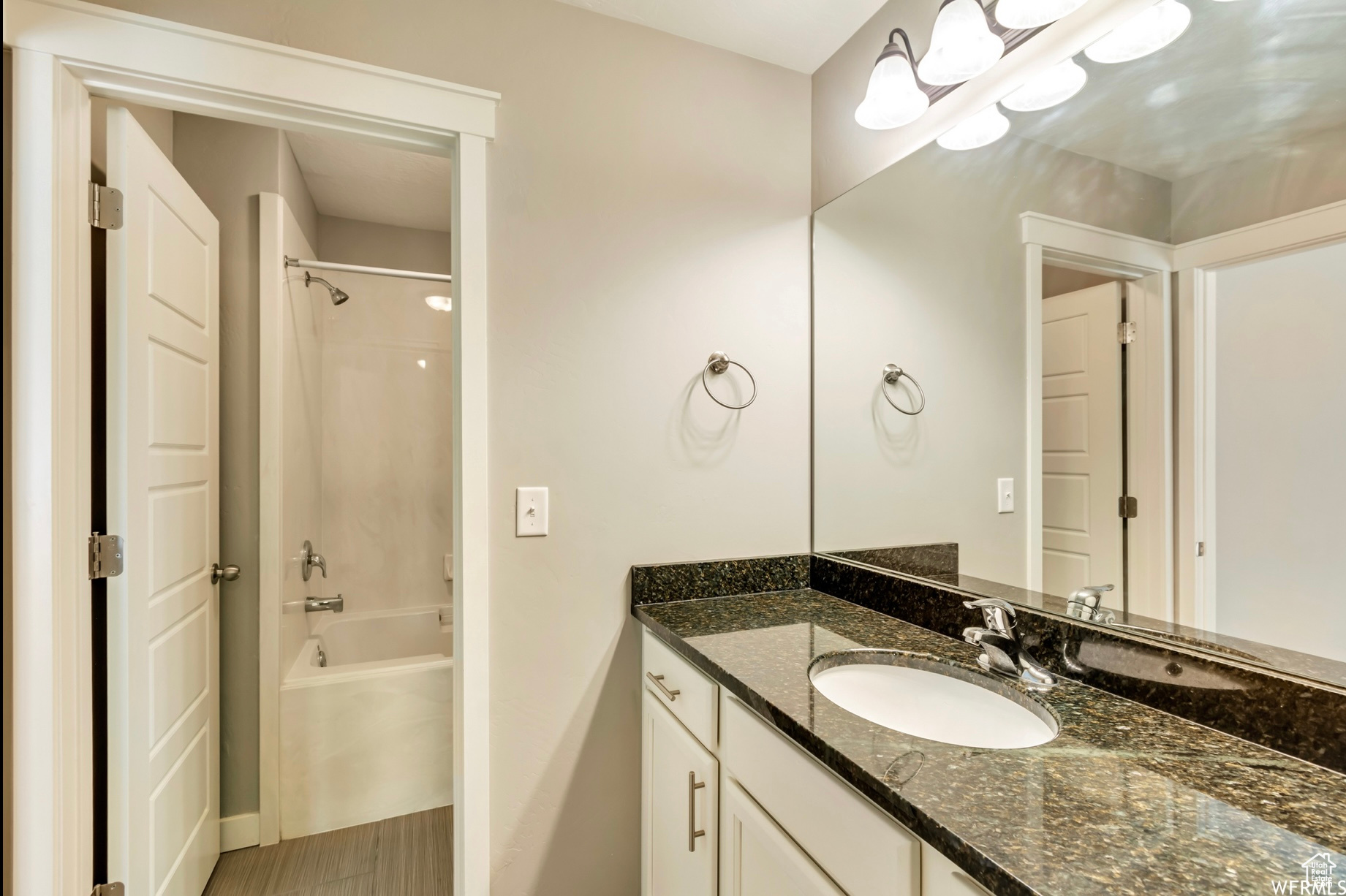 Bathroom featuring shower / bath combination, vanity with extensive cabinet space, and tile floors