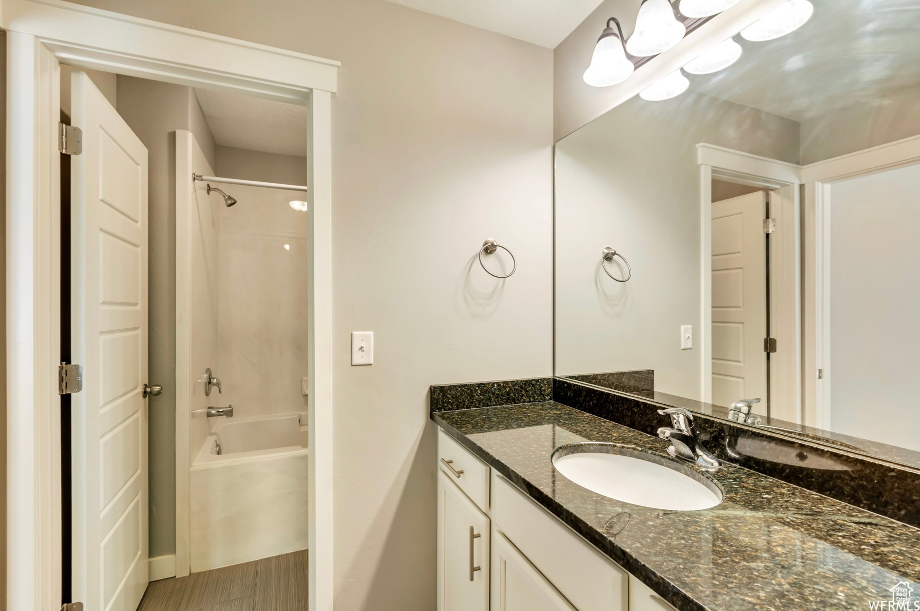 Bathroom with tile flooring, shower / tub combination, and large vanity