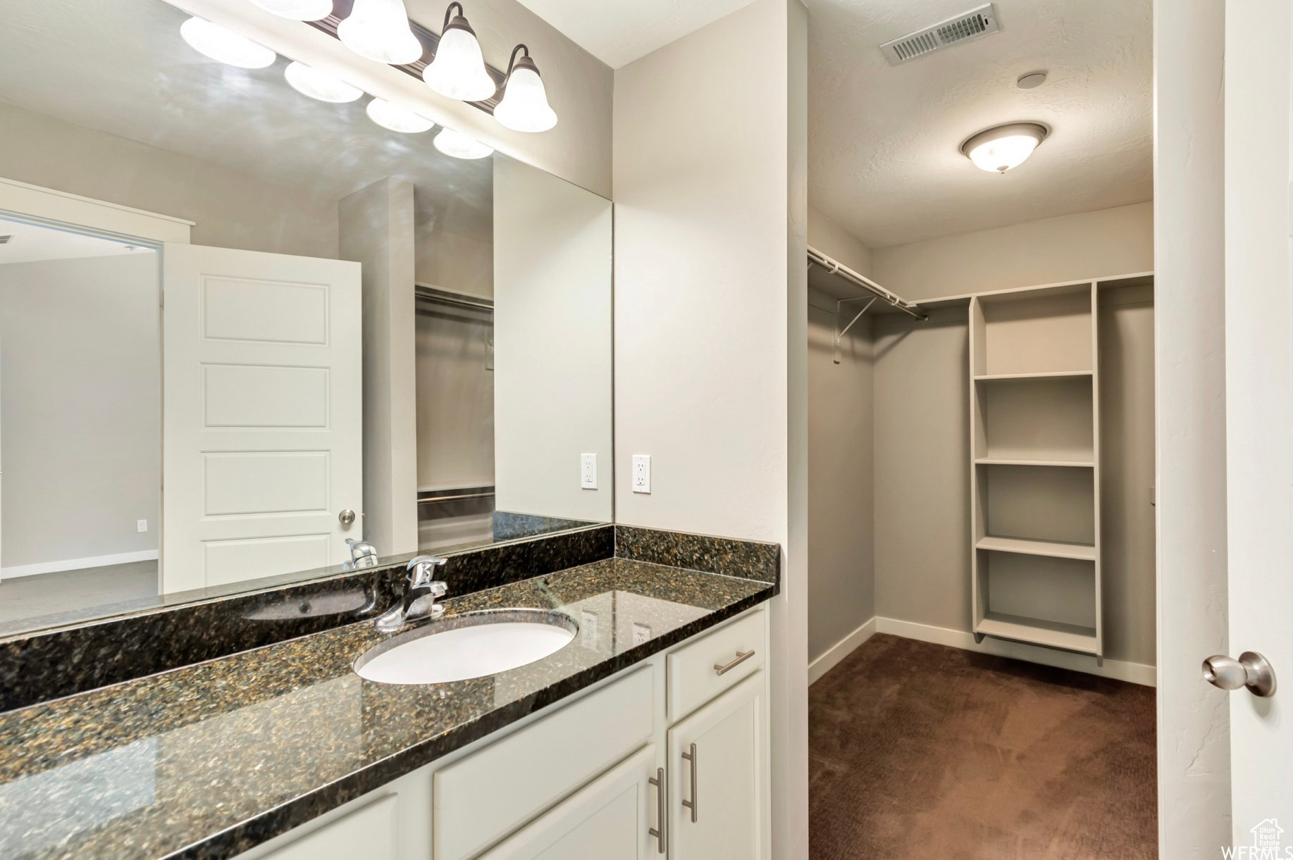 Bathroom featuring vanity with extensive cabinet space