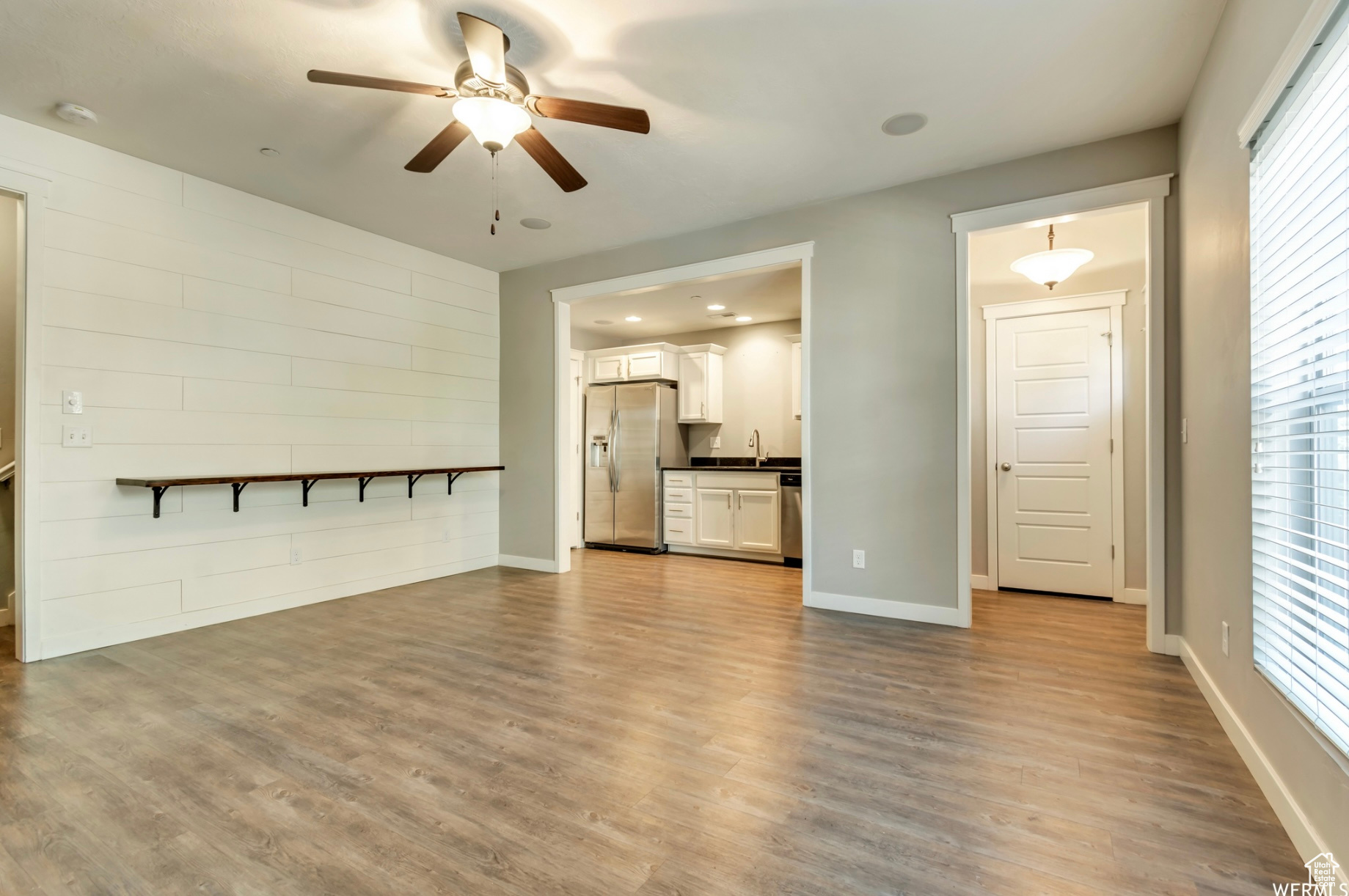 Unfurnished living room with ceiling fan and wood-type flooring