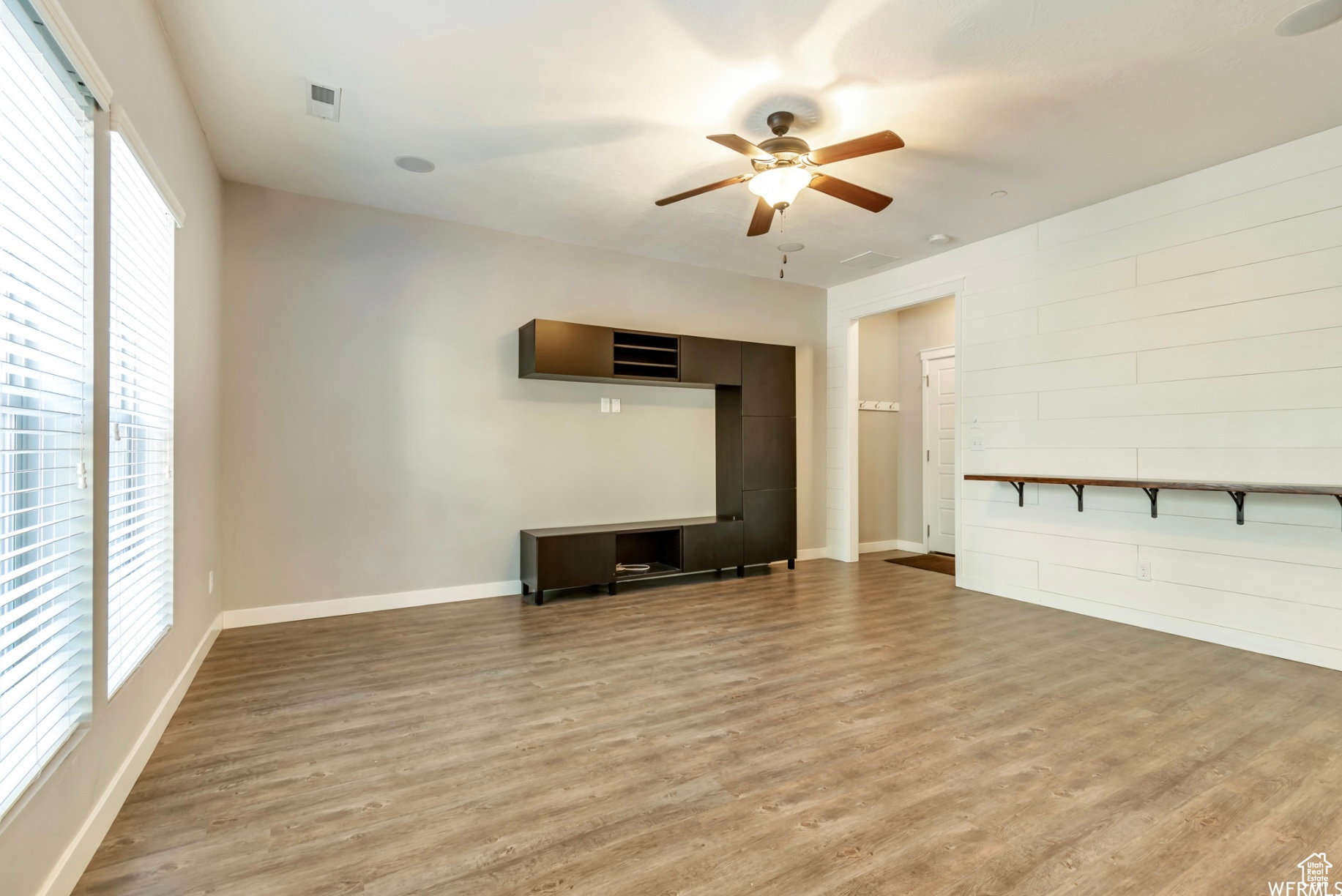 Unfurnished living room with light hardwood / wood-style floors, plenty of natural light, and ceiling fan