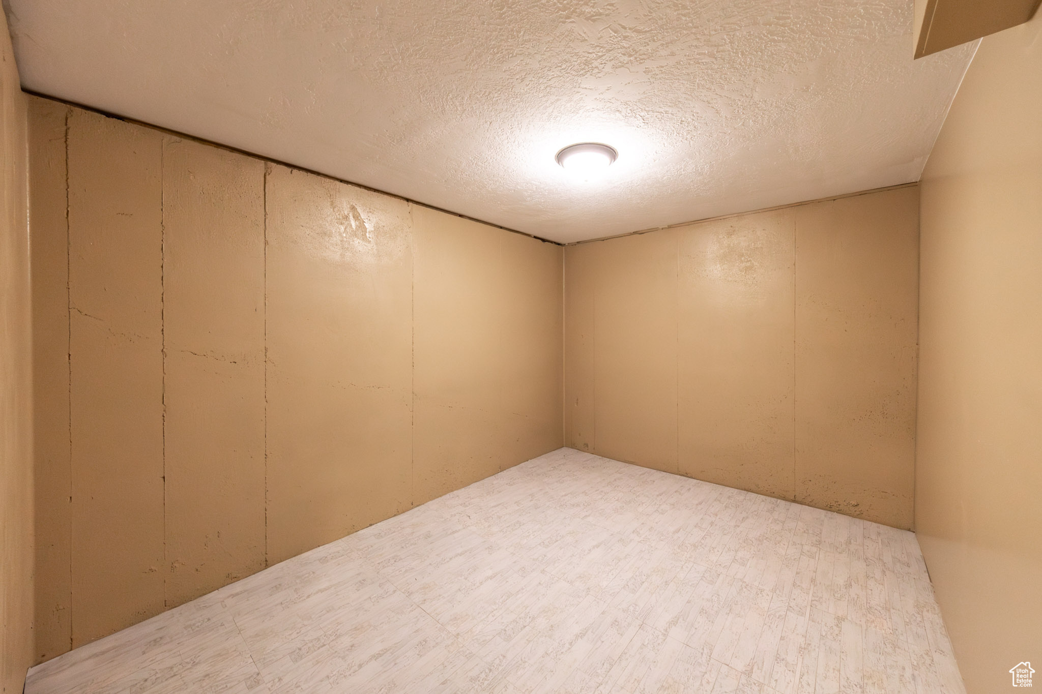 This basement room sits under the garage with concrete walls. Can serve as office or large storage room.