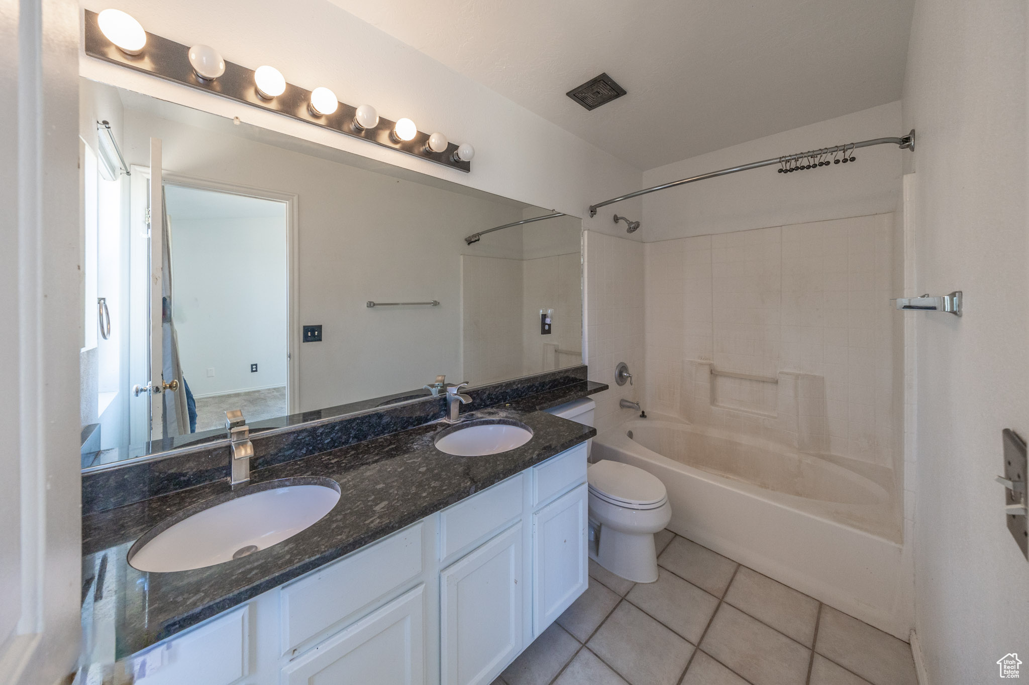 Full master bathroom with tile flooring, dual vanity, tub / shower combination, vanity with extensive cabinet space