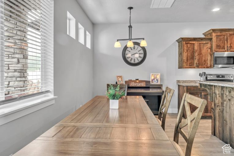 Dining area with a healthy amount of sunlight and light hardwood / wood-style floors